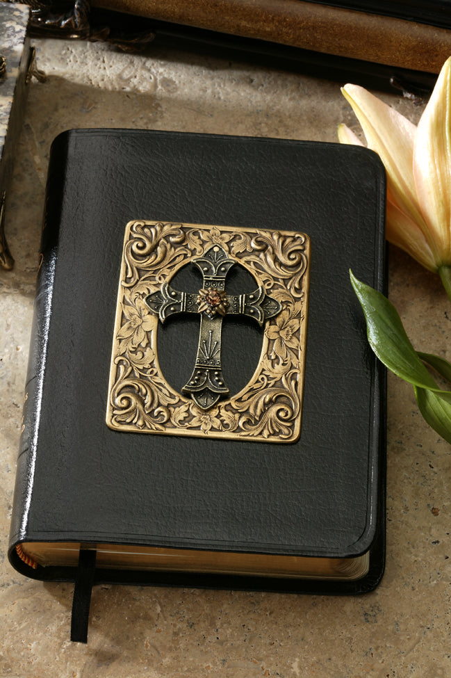 Jo Marz compact size jeweled Bible with cross and amber crystal on black cover placed on a stone surface