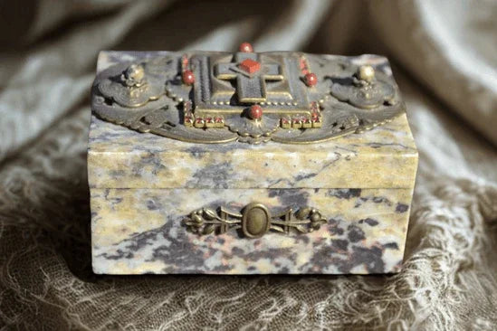Jeweled soapstone keepsake box with ornate metal and gemstone accents on a dark background