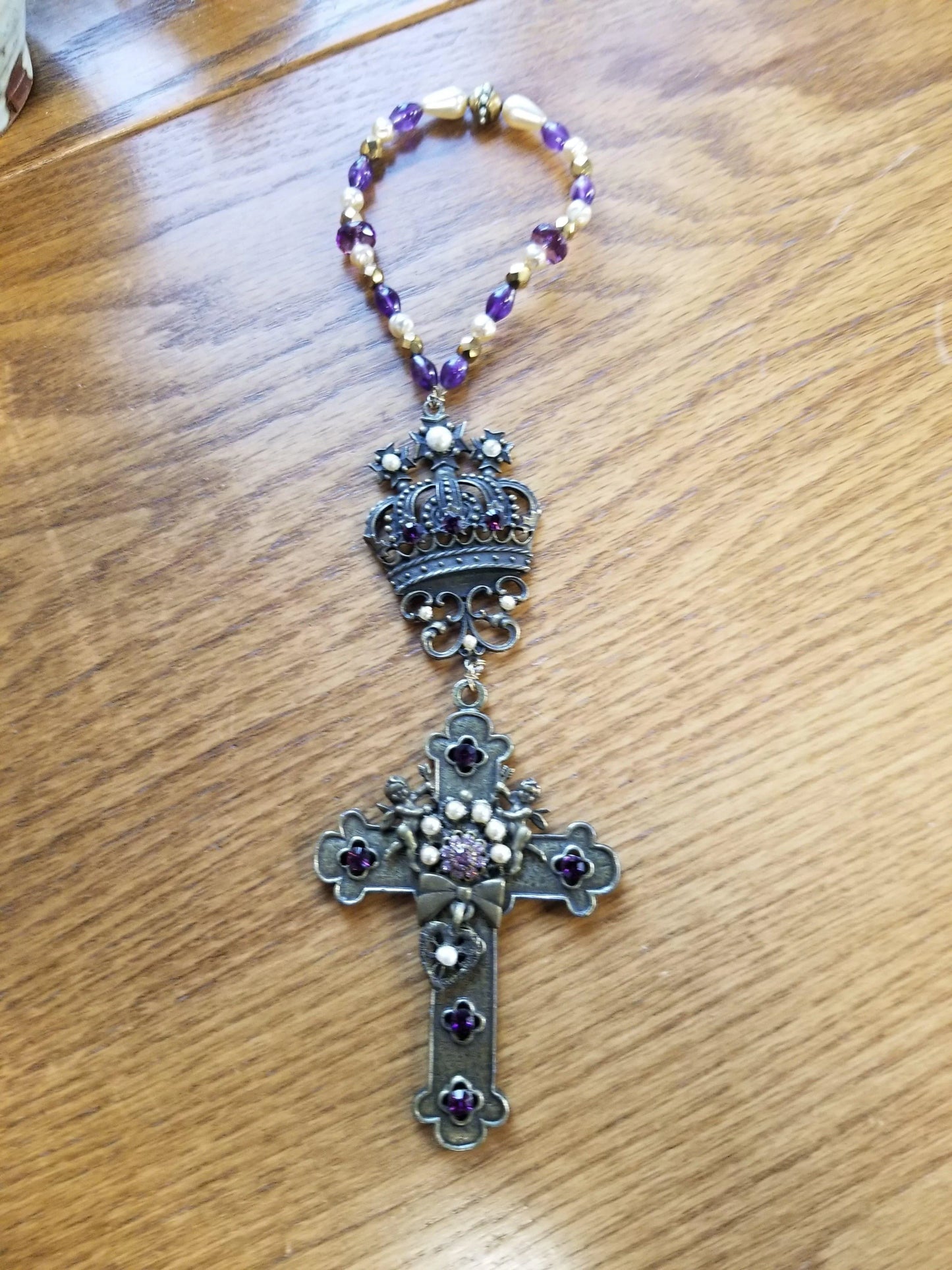 Dacole Designs jeweled cross room blessing gift with purple beads and decorative crown on wood background