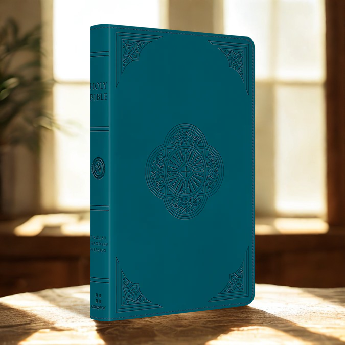 ESV thinline Bible leather teal with embossed design standing on wooden surface in natural light