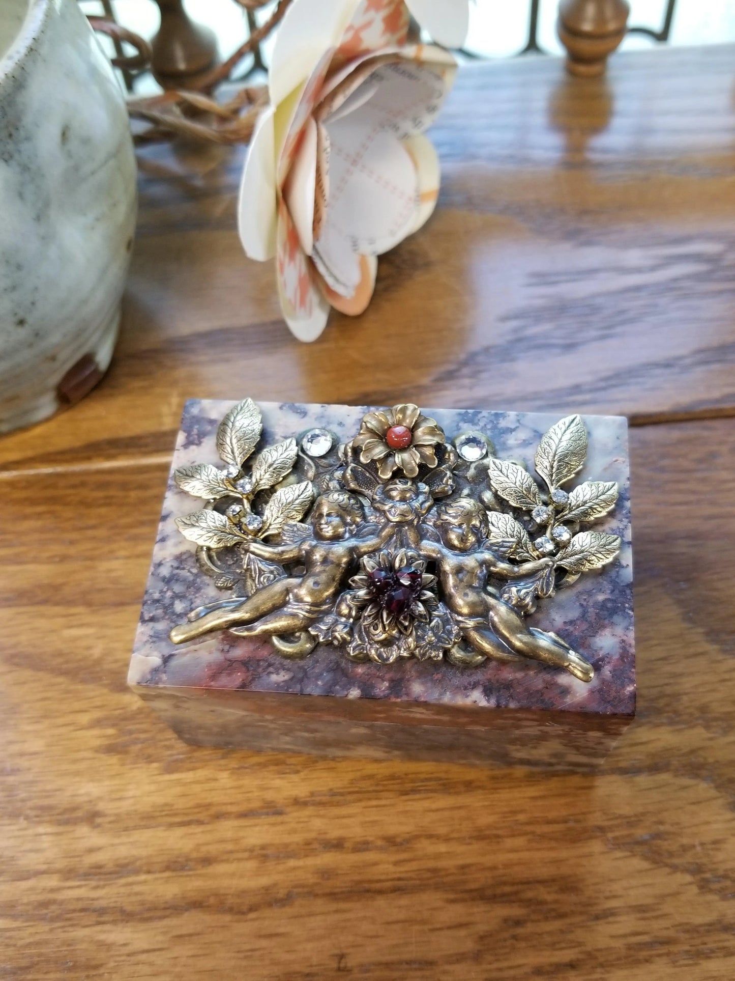 Dacole Designs cherub soapstone keepsake box with ornate gold cherubs and floral decorations on wooden surface