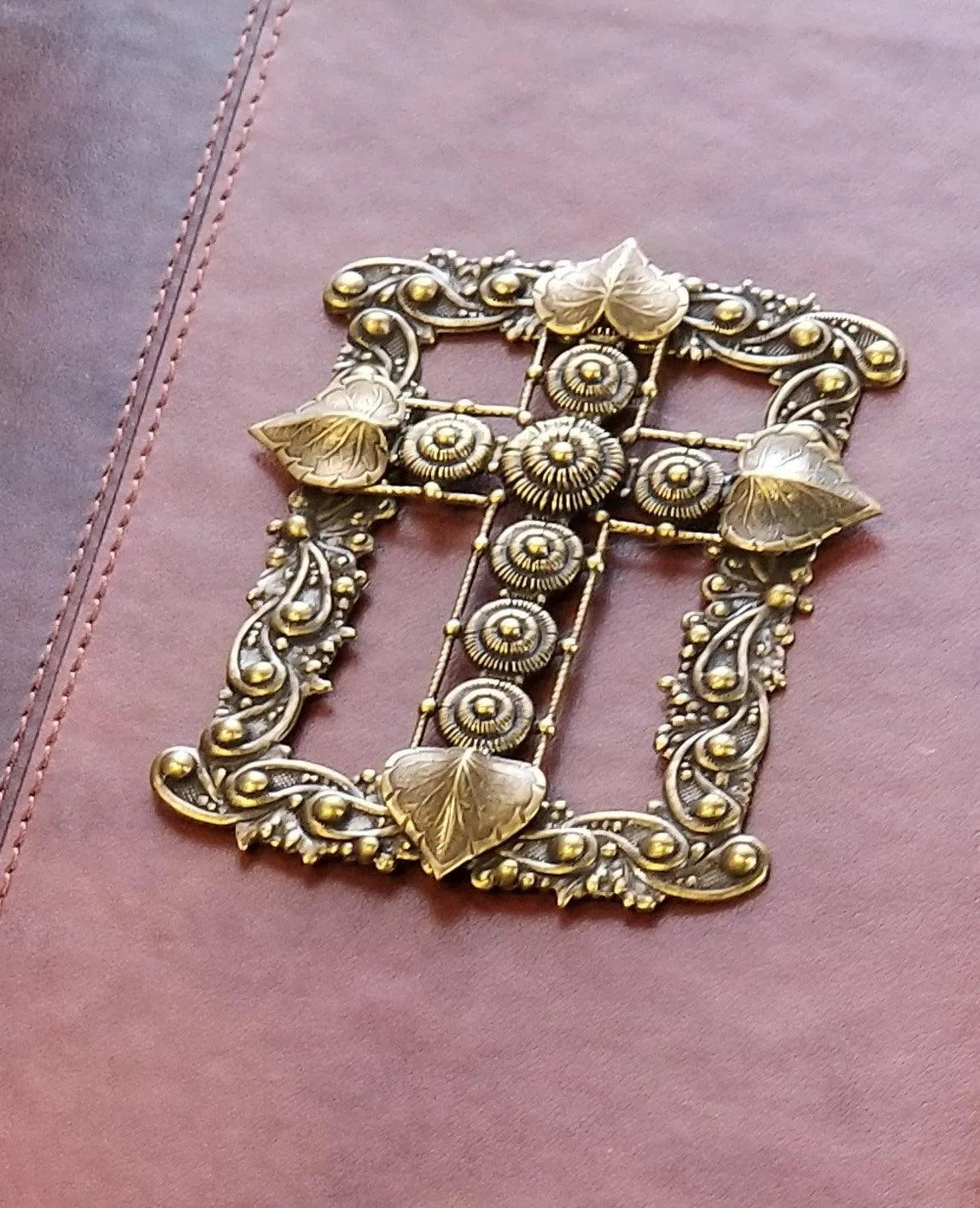 Close-up of decorative gold jeweled cross on brown leather cover of giant print jeweled KJV Bible