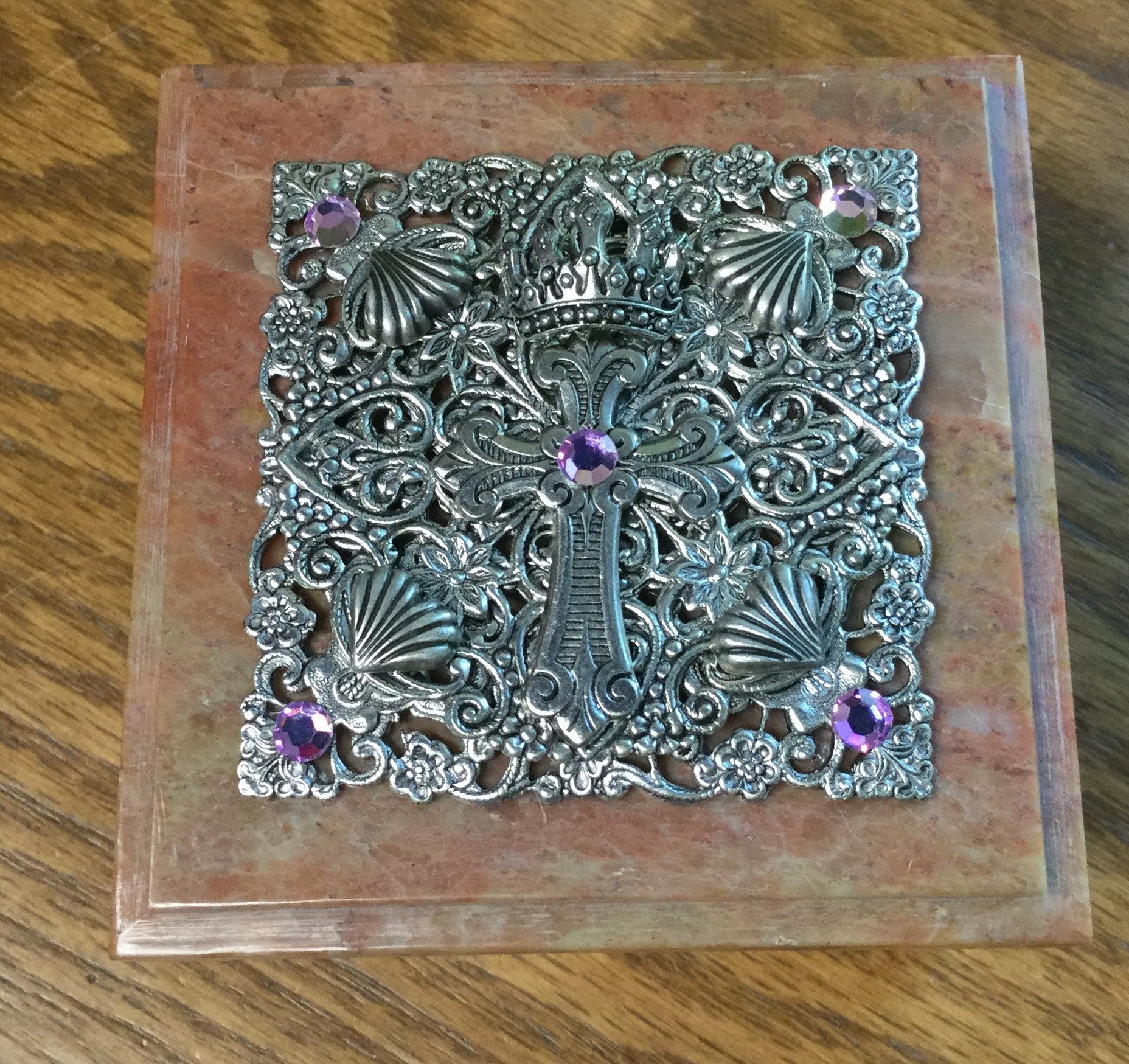 Dacole Designs jeweled baby keepsake box with ornate silver cross and purple gemstones on wooden surface