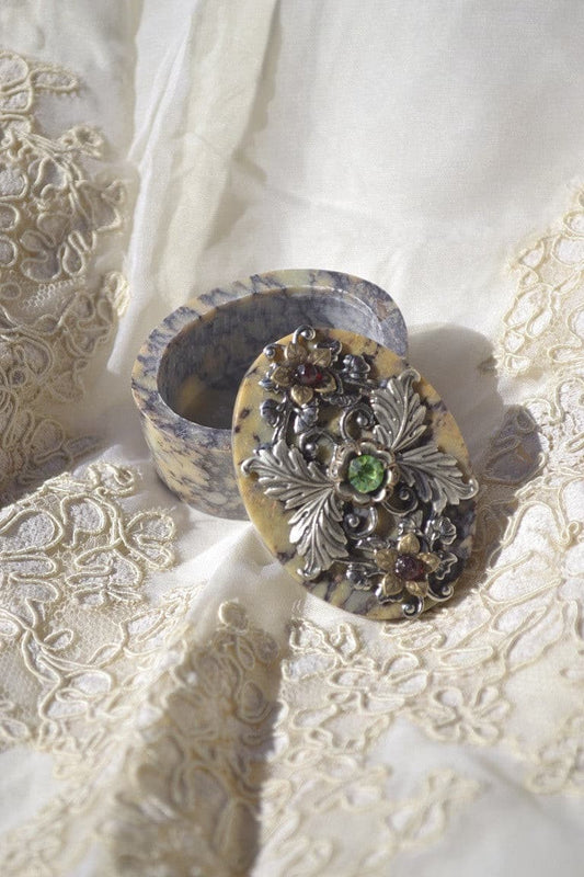 Dacole Designs jeweled soapstone keepsake box with ornate silver floral design and gemstones on lace background
